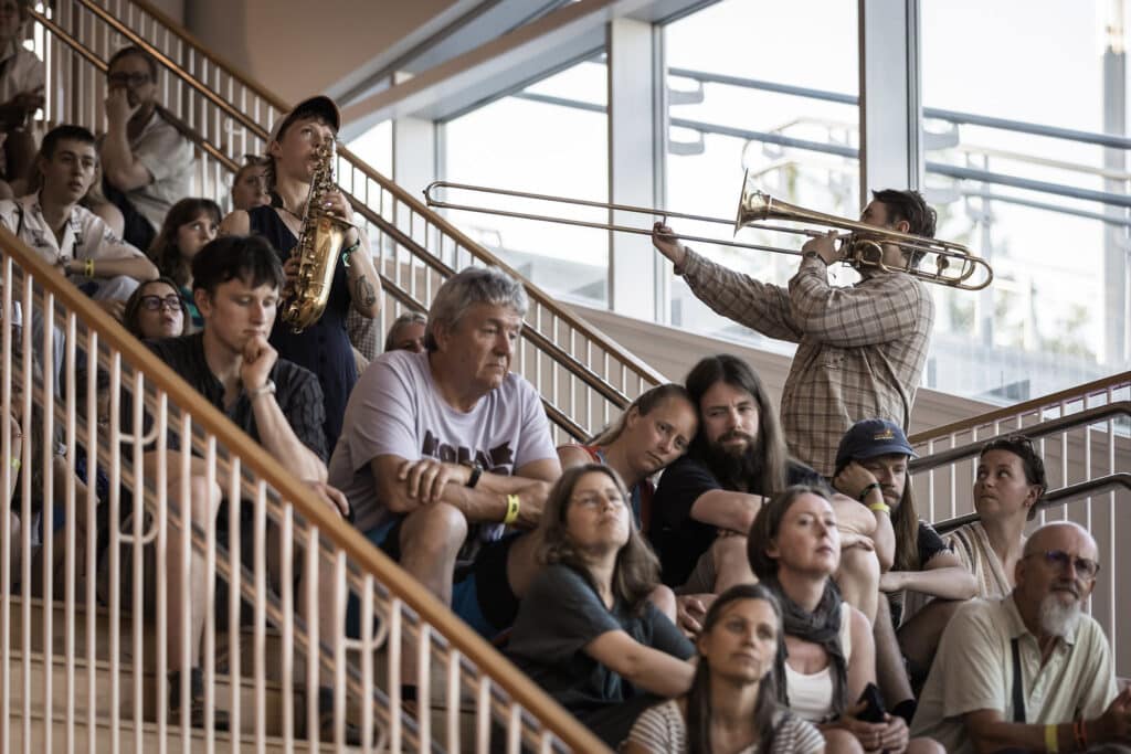 Saksofonist Signe Emmeluth og trombonist Emil Bø blant publikum i trappa under TJO-festen på plassen. Foto: Ole Bjørn Steinsvik/Moldejazz